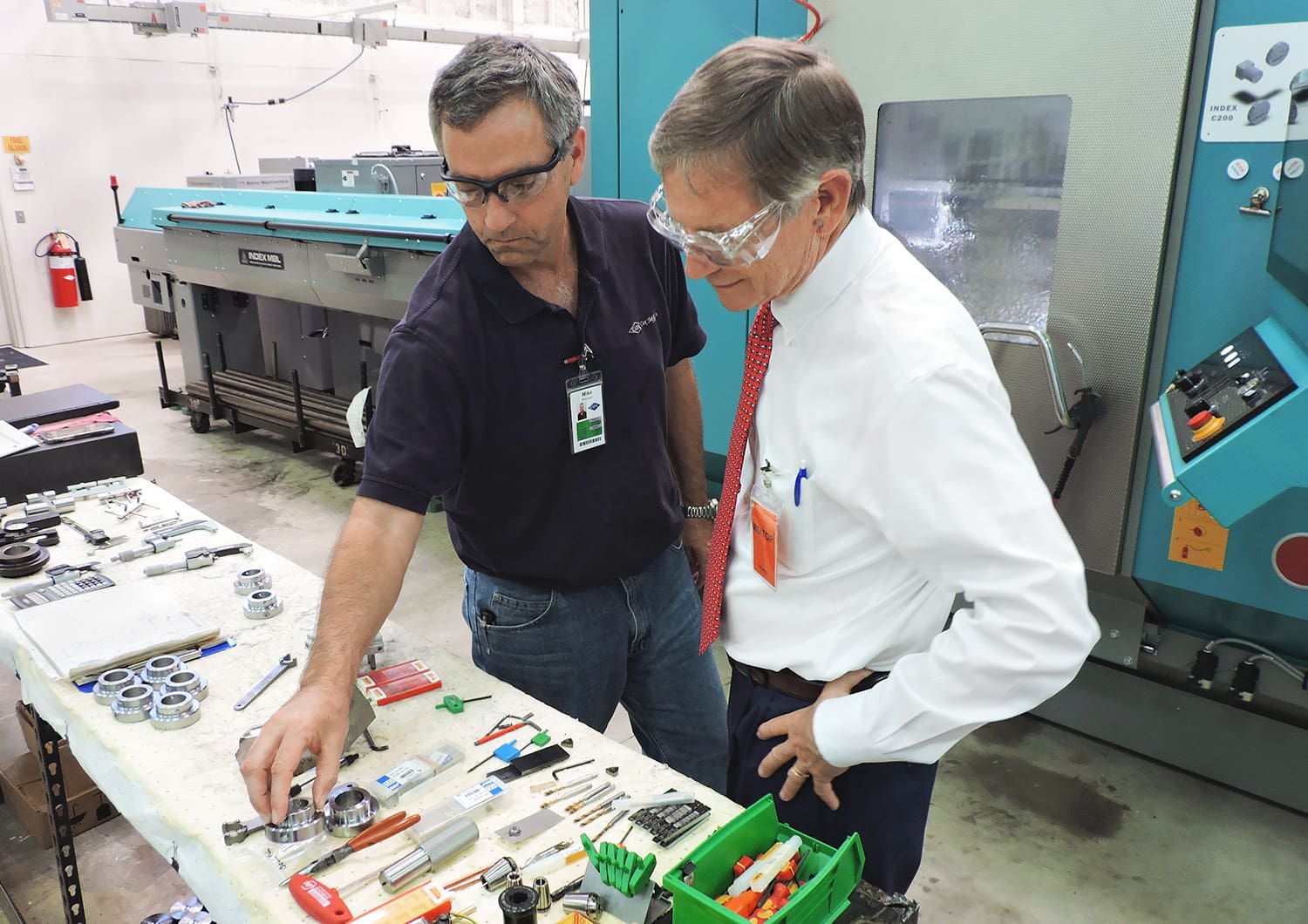 VP of Manufacturing Mike Petrusch shows Congressman Lamar Smith different tooling used for CNC machines.