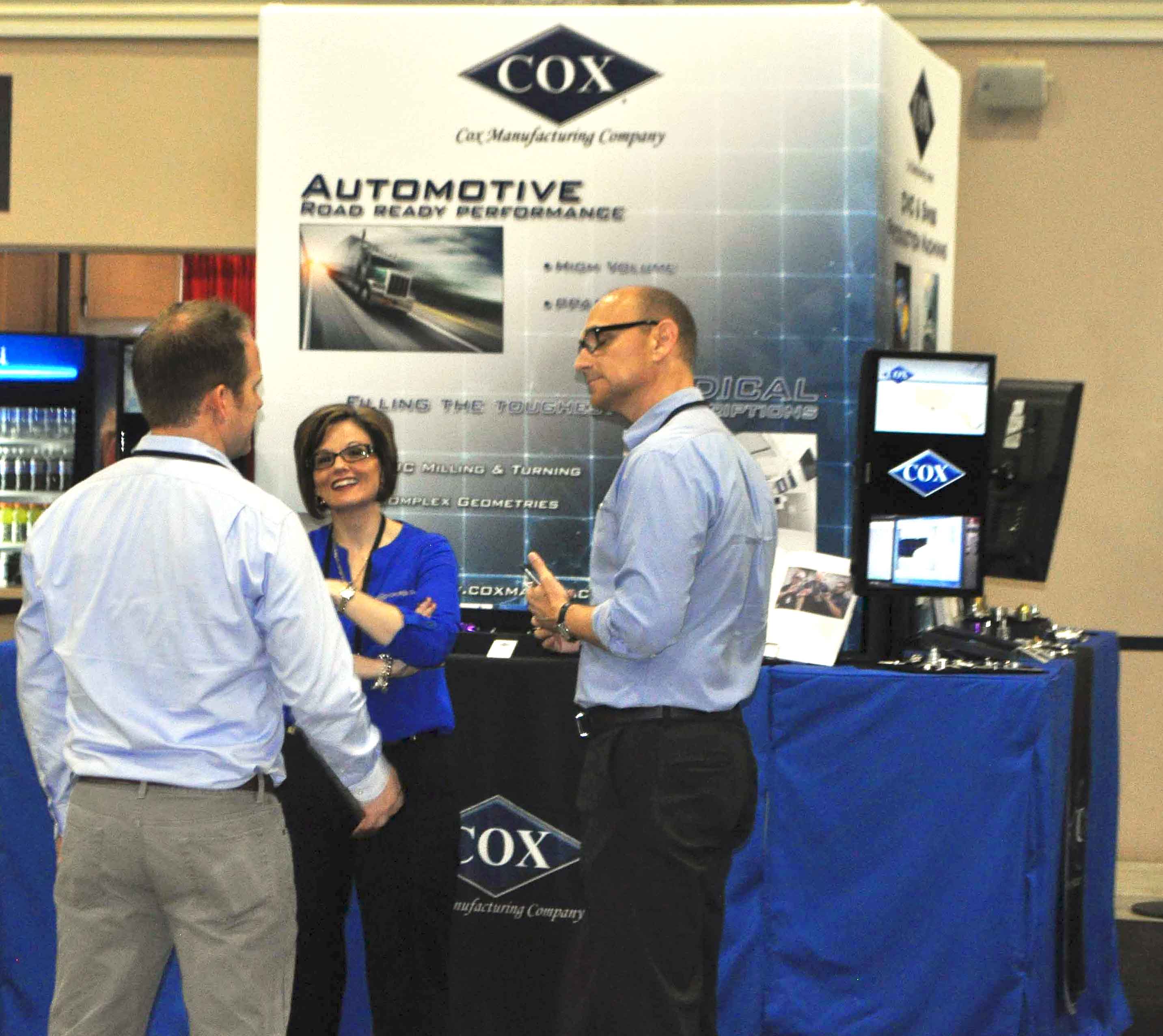 Cox Mfg account managers and booth visitor.